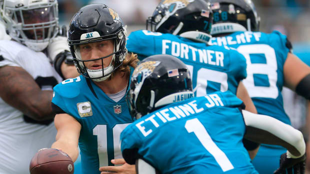 Jacksonville Jaguars quarterback Trevor Lawrence hands off to Travis Etienne.